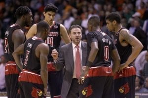 Louisville head coach Rick Pitino, center, talks to players during a time out in the second half of an NCAA college basketball game against Miami, Tuesday, Feb. 3, 2015, in Coral Gables, Fla. Louisville defeated Miami 63-55. (AP Photo/Wilfredo Lee),