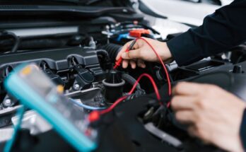 A vehicle technician servicing the car's battery and electrical system to ensure proper wiring and charging.