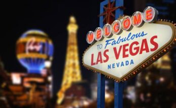 The iconic Las Vegas Sign with a few casino resorts behind it, including Paris and the Eiffel Tower restaurant.