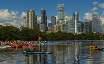 A group of kayakers, canoers, and paddleboarders congregates on the water at Lady Bird Lake in Austin, Texas.